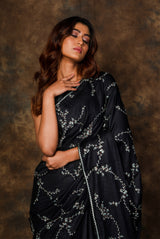 A woman wearing black pure tussar embroidered saree, latest saree, new saree collection