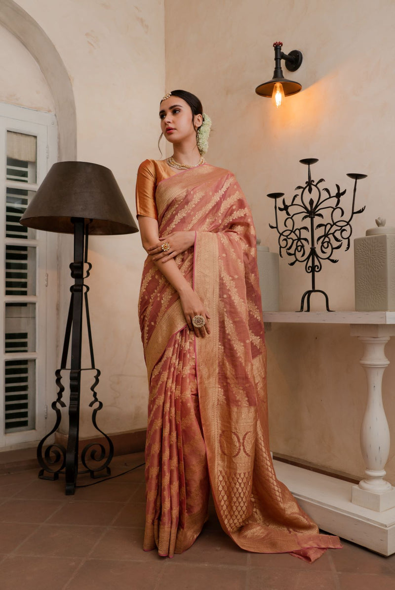 A woman wearing pure georgette tissue saree in dusty rose, latest saree, new saree collection
