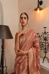 A woman wearing pure georgette tissue saree in dusty rose, latest saree, new saree collection