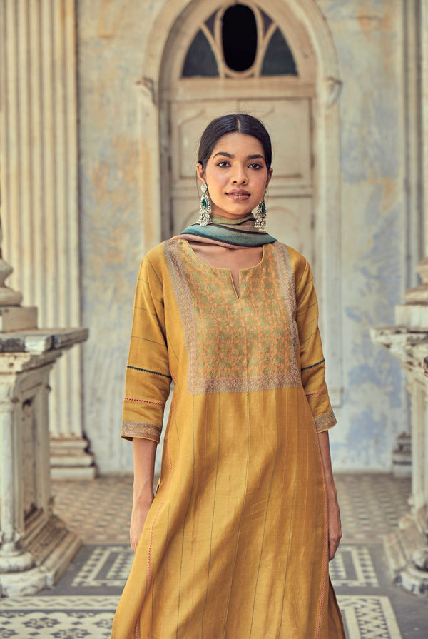 A women wearing mustard party wear salwar suit, ethnic wear for women.