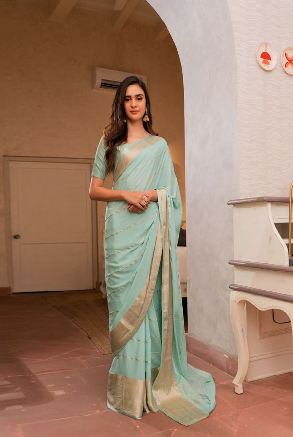 A woman wearing pure crepe pastel blue saree, latest saree, new saree collection