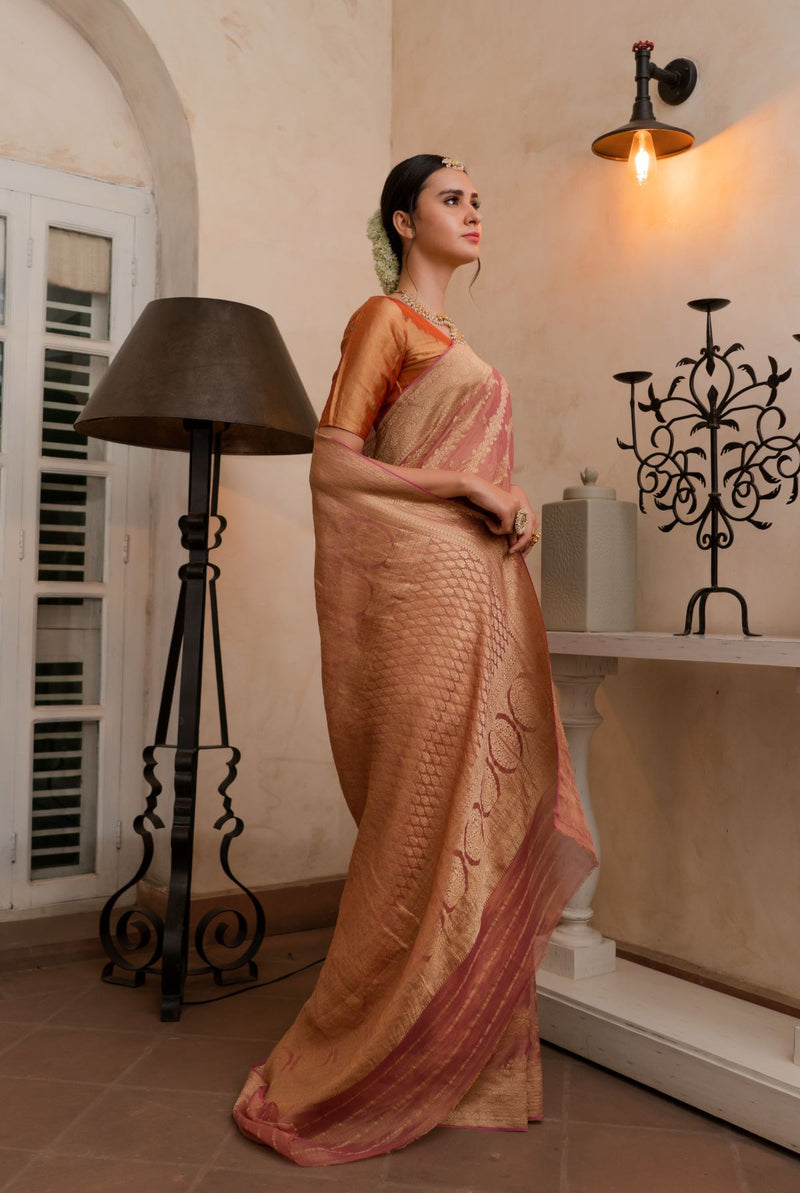 A woman wearing pure georgette tissue saree in dusty rose, latest saree, new saree collection