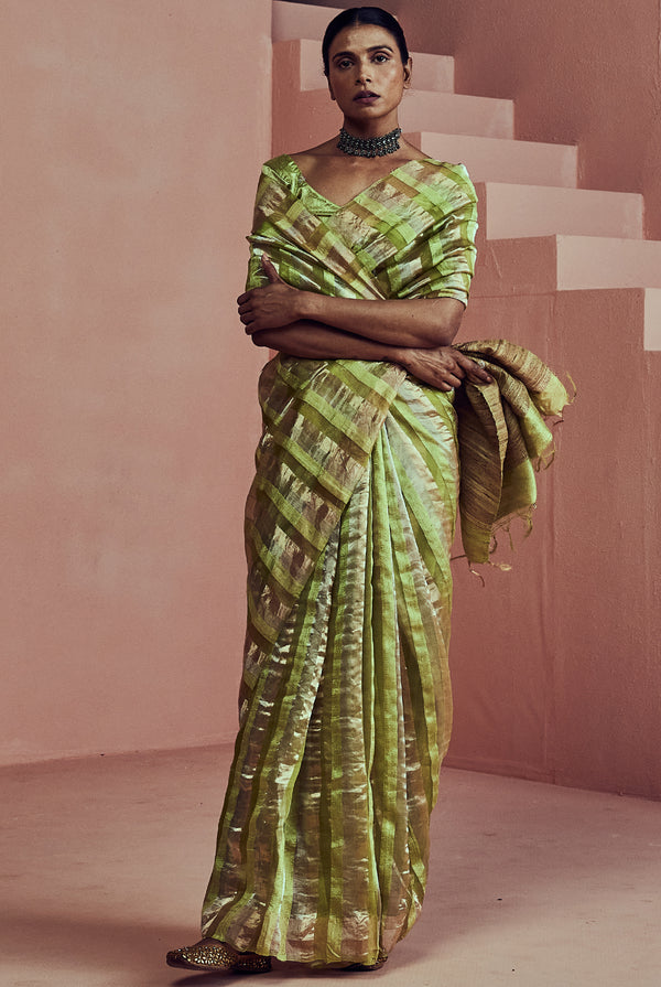 A women wearing green pure tissue striped saree, party wear for women.