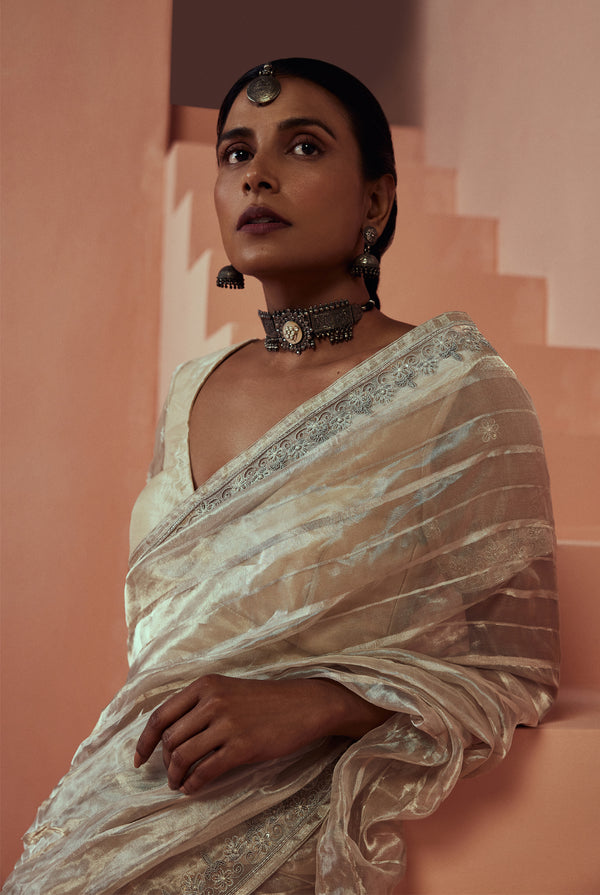 A women wearing pure silver tissue saree with woven stripes, party wear for women.