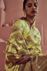 A women wearing yellow pure tissue striped saree, party wear for women.