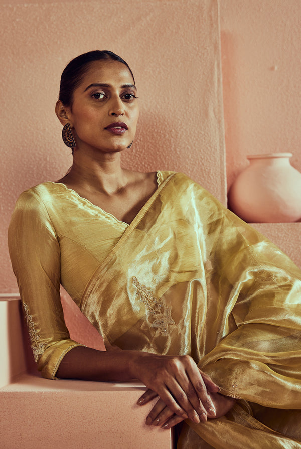 A women wearing yellow pure tissue saree with handwork, traditional wear for women.